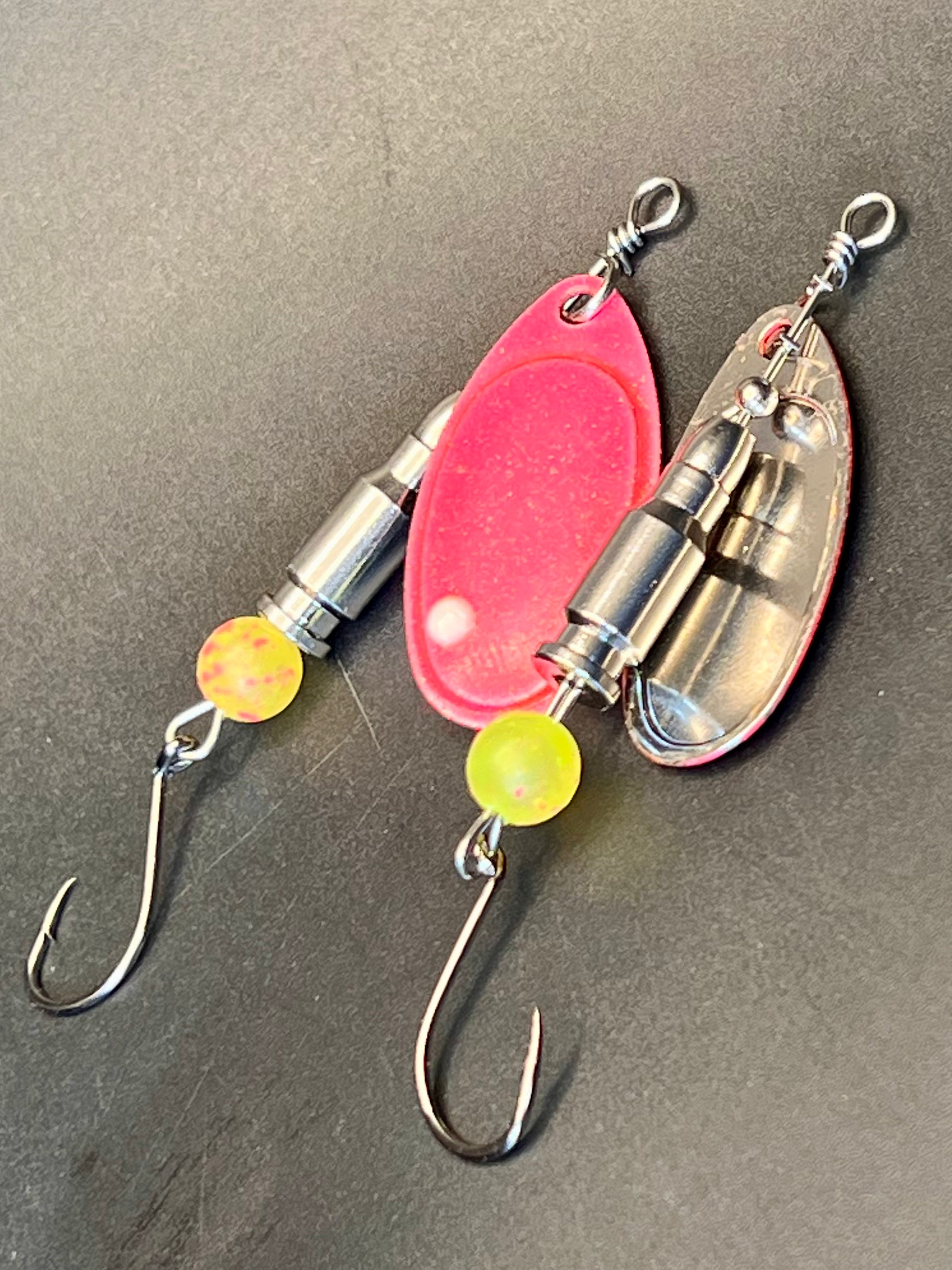 Glow-in-the-dark inline spinner lure with chrome bullets, pink blade, yellow beads, hooks