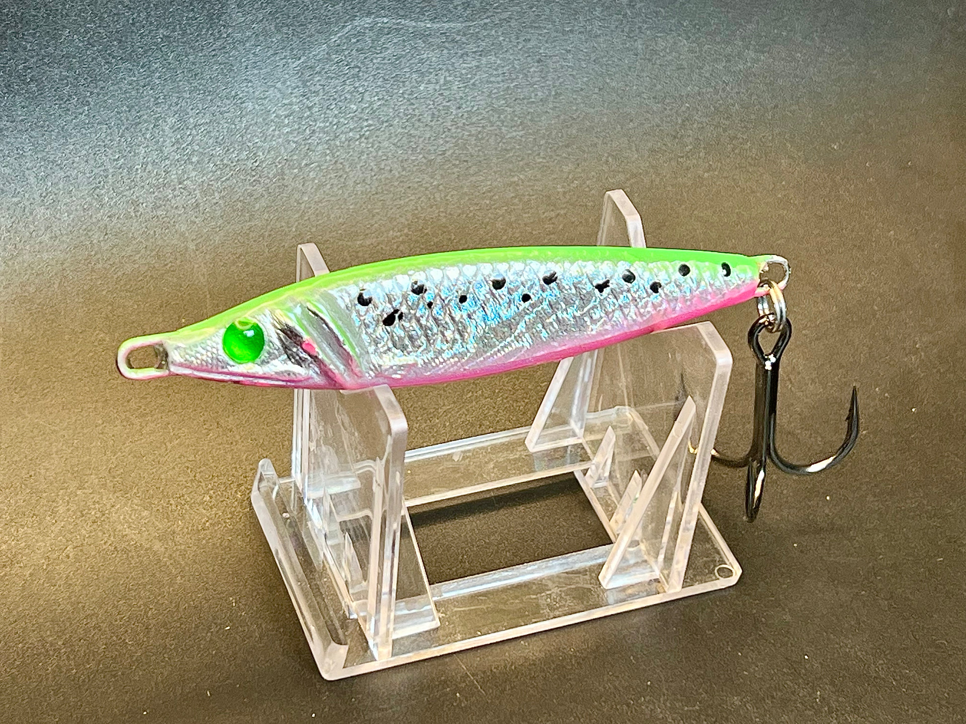 Green and pink jigging spoon fishing lure with treble hook
