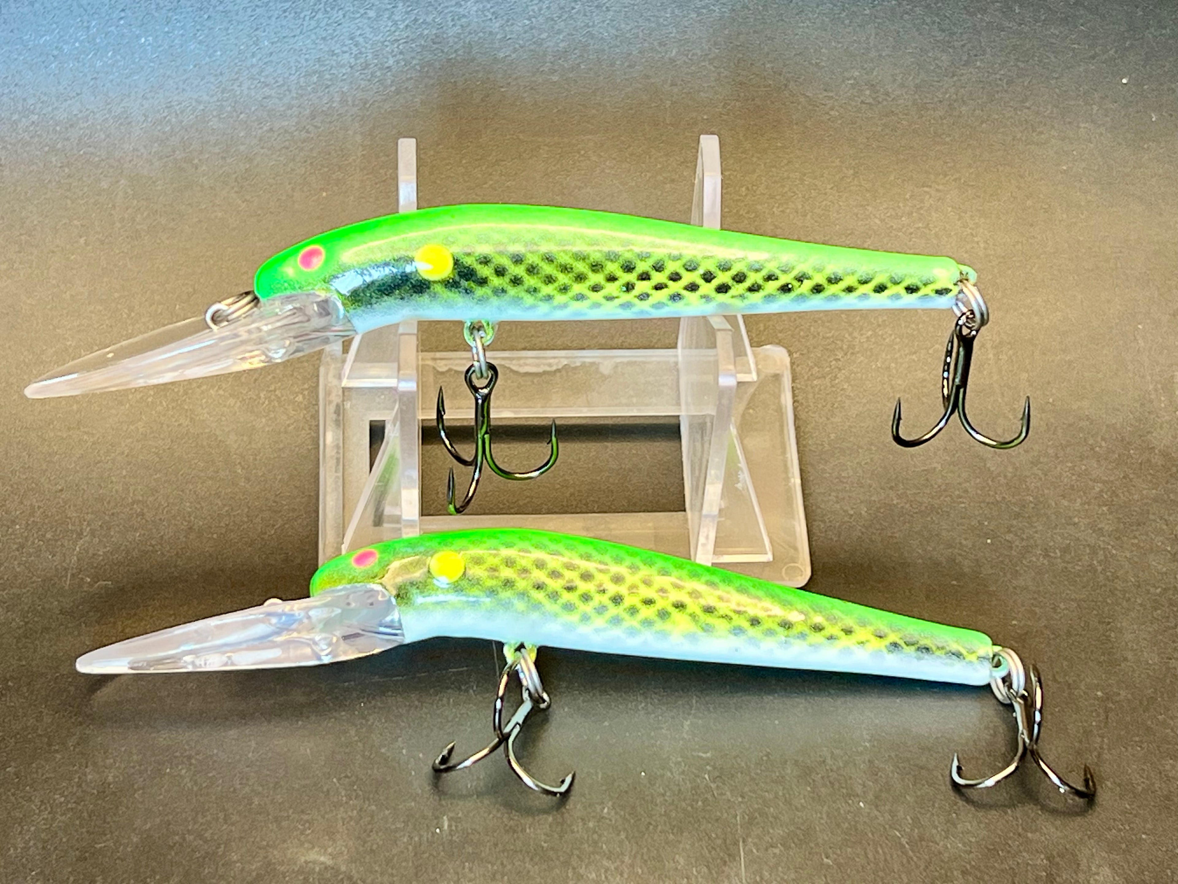 Two UV glow lightningstick fishing lures, green translucent bodies with treble hooks on clear stand