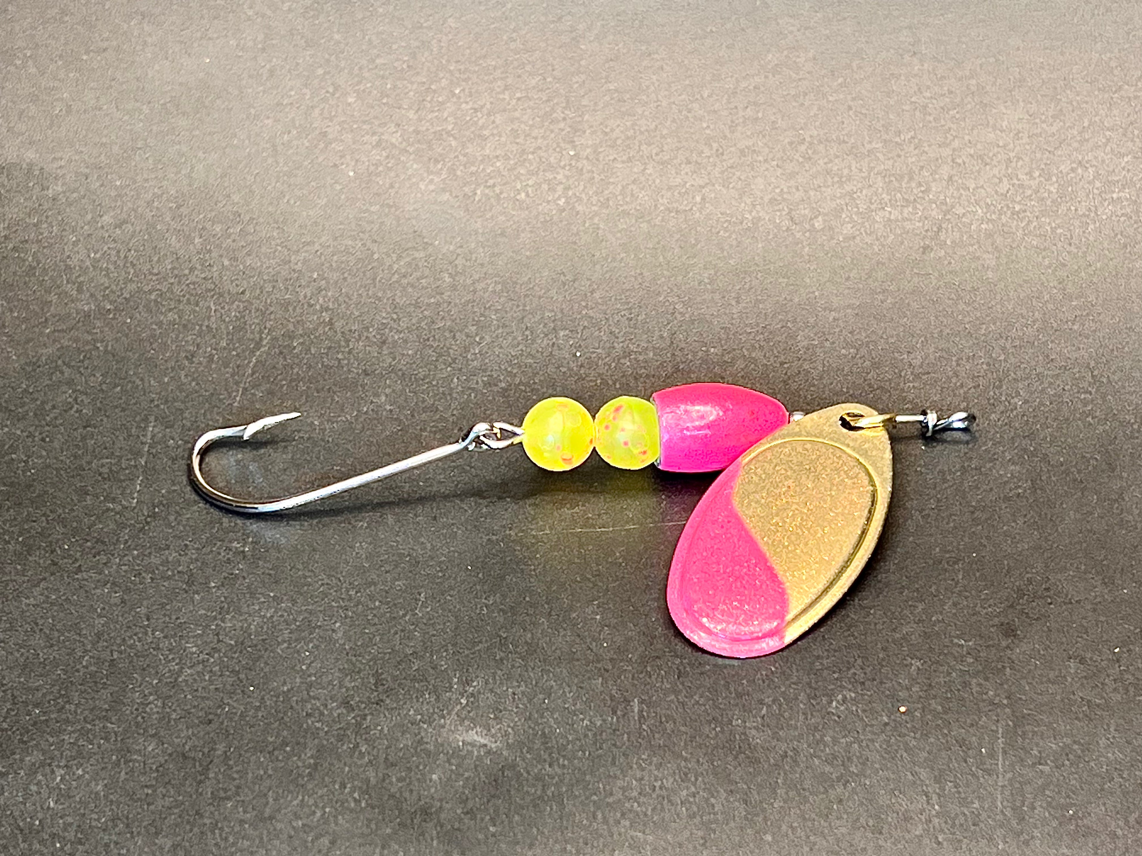 Pink and gold inline spinner fishing lure with treble hook