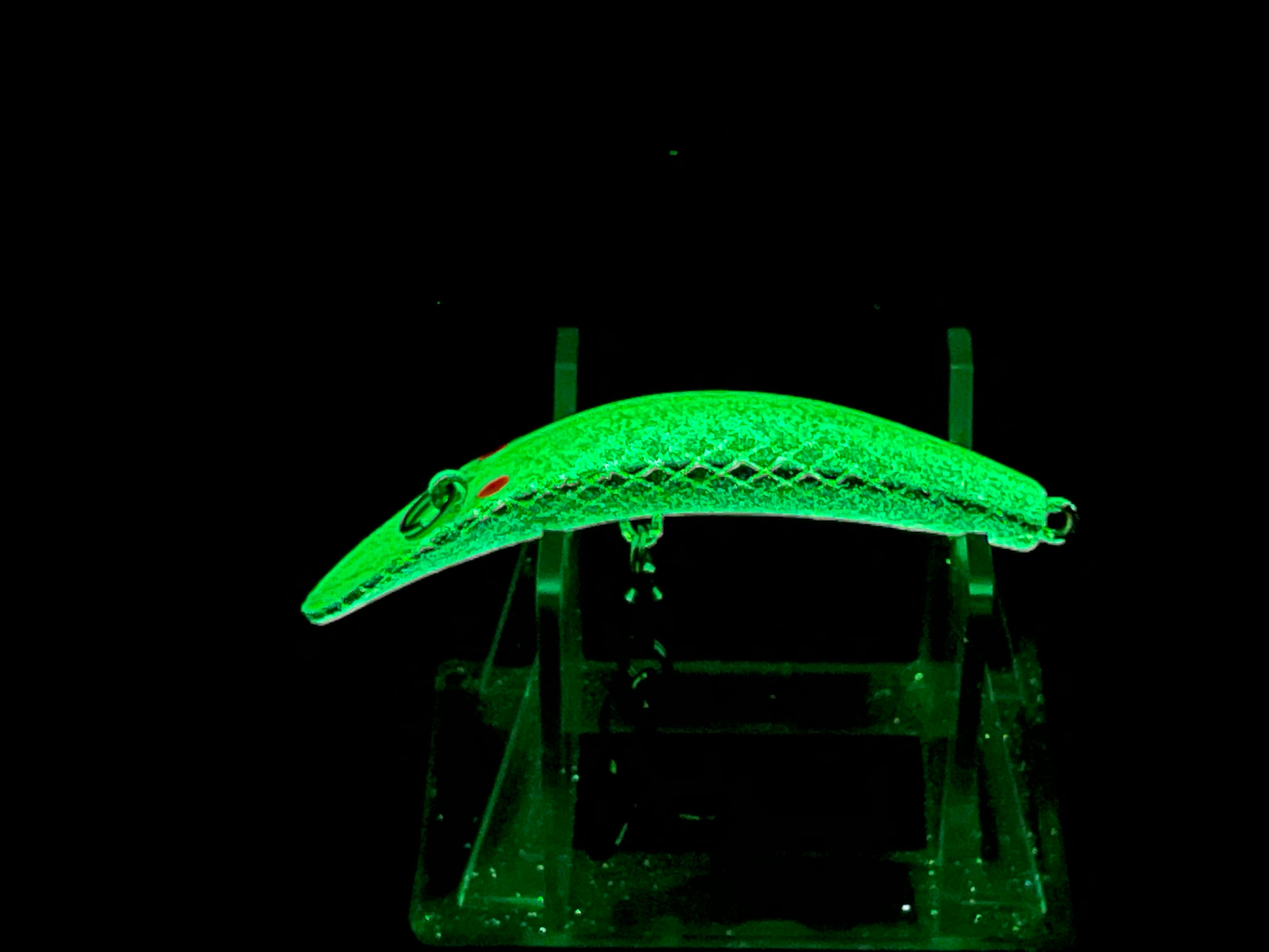 UV glow green fish-shaped fishing lure with two treble hooks on clear mount