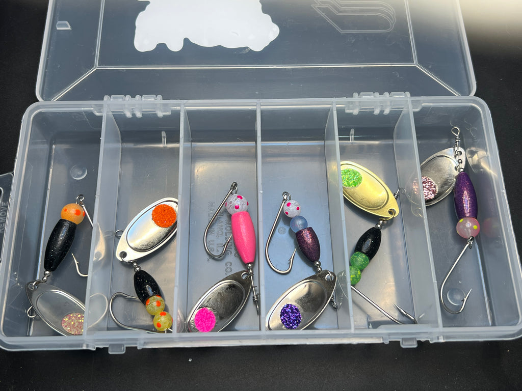Clear tackle box with assorted colorful fishing spinner lures and hooks