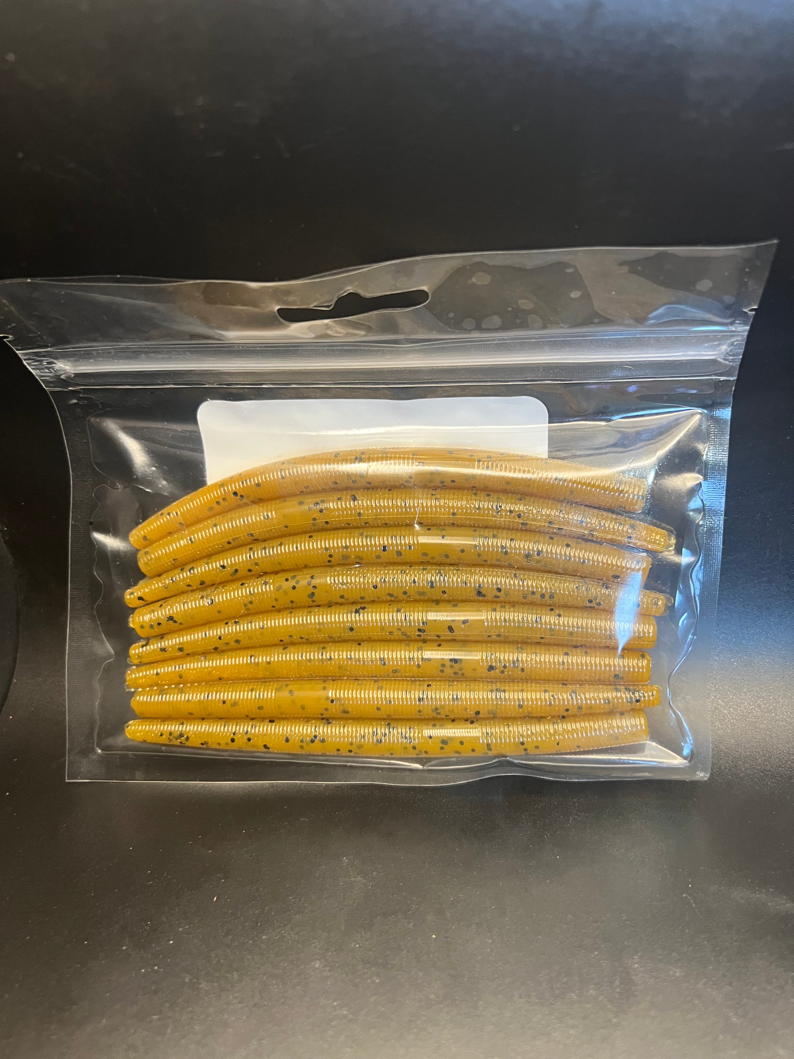 Soft plastic stickbait worms in yellow-gold with speckled dots inside clear blister pack
