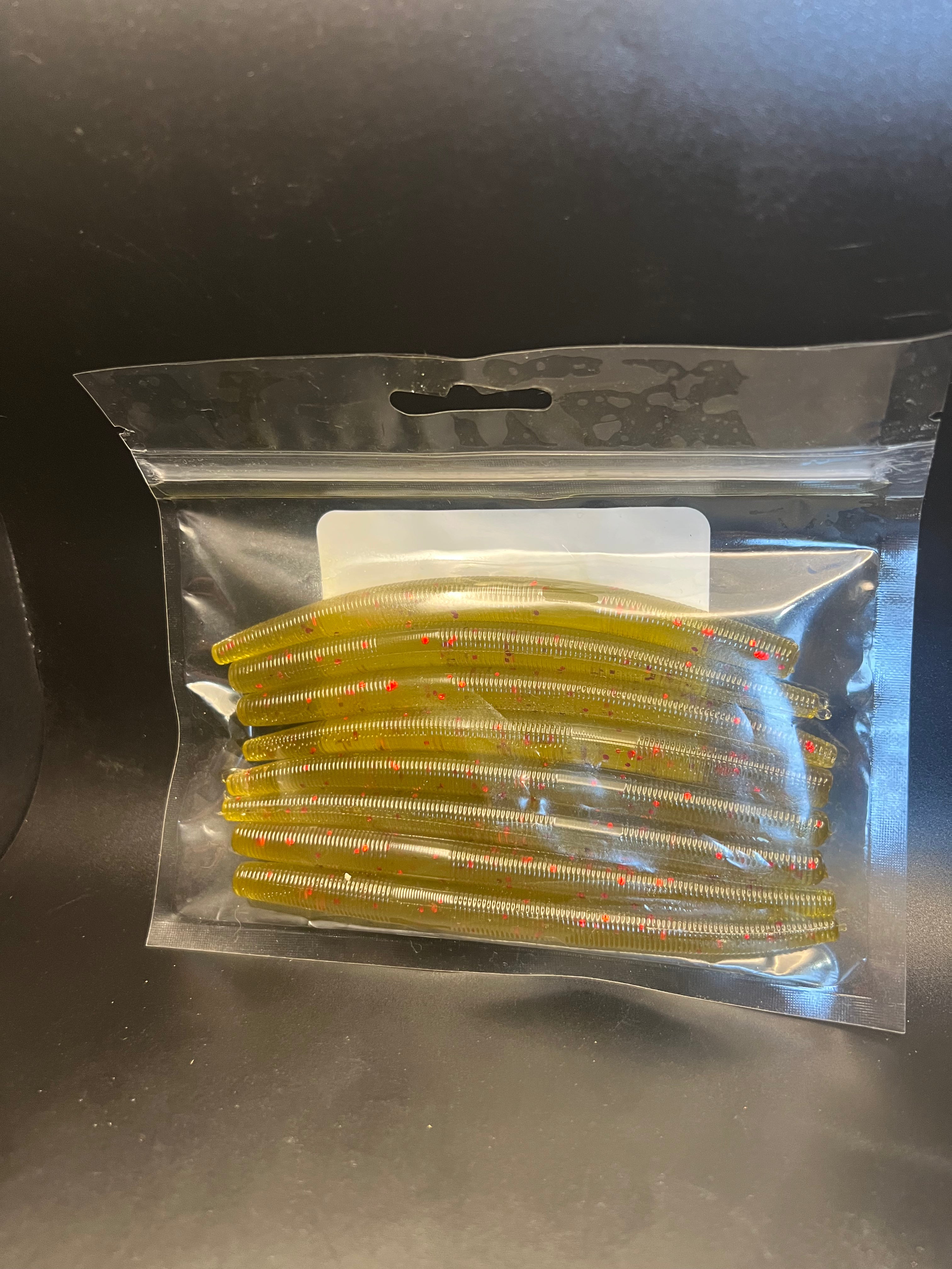 Soft plastic stickbait worms in pale gold with red flecks inside clear blister pack