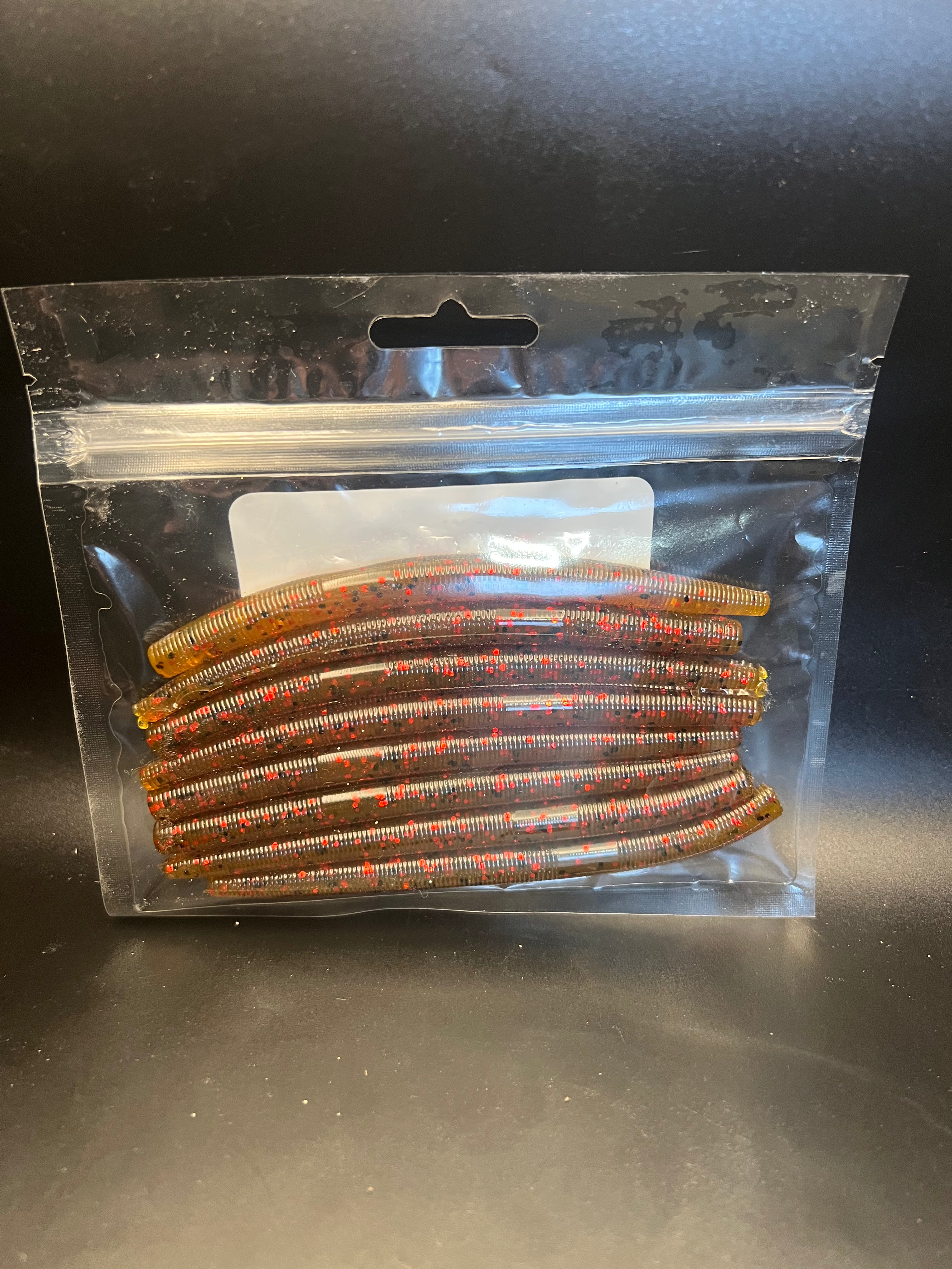 Soft plastic stickbait worms in brown with iridescent speckles inside clear blister pack