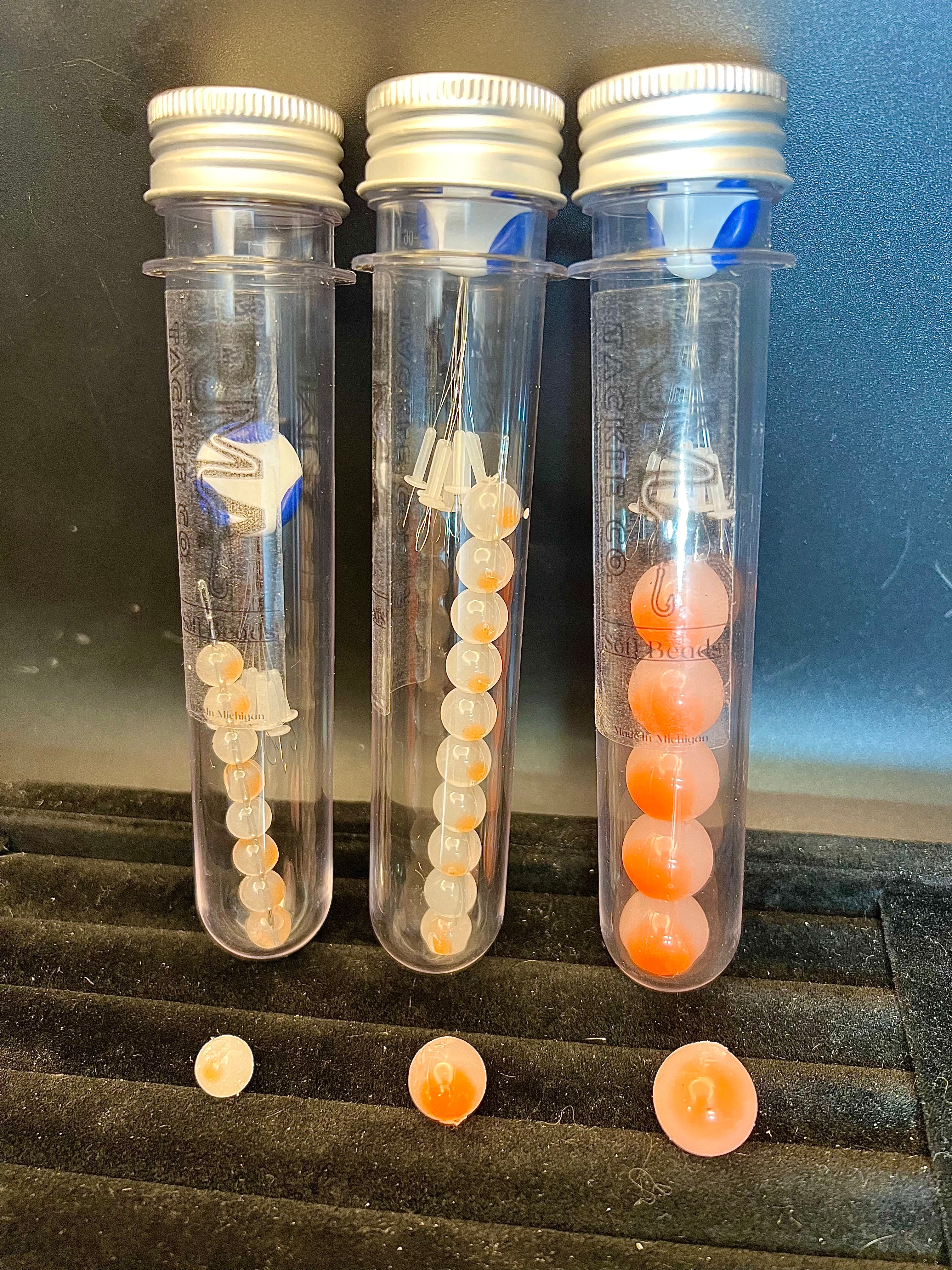 Grapefruit embryo soft plastic beads: orange and pale yellow beads in clear tubes