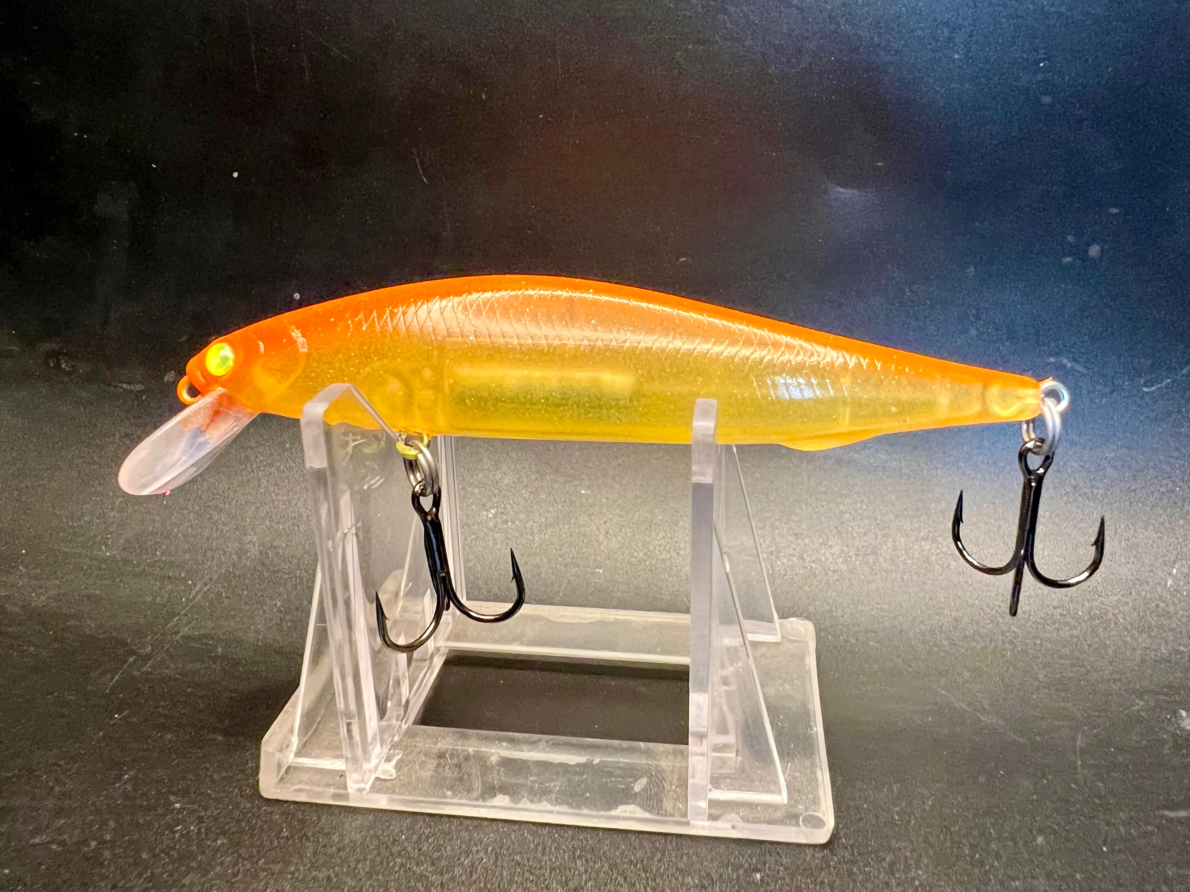 Mango Shiner 4.25in jerkbait, orange-yellow lure with green eye, 3 hooks