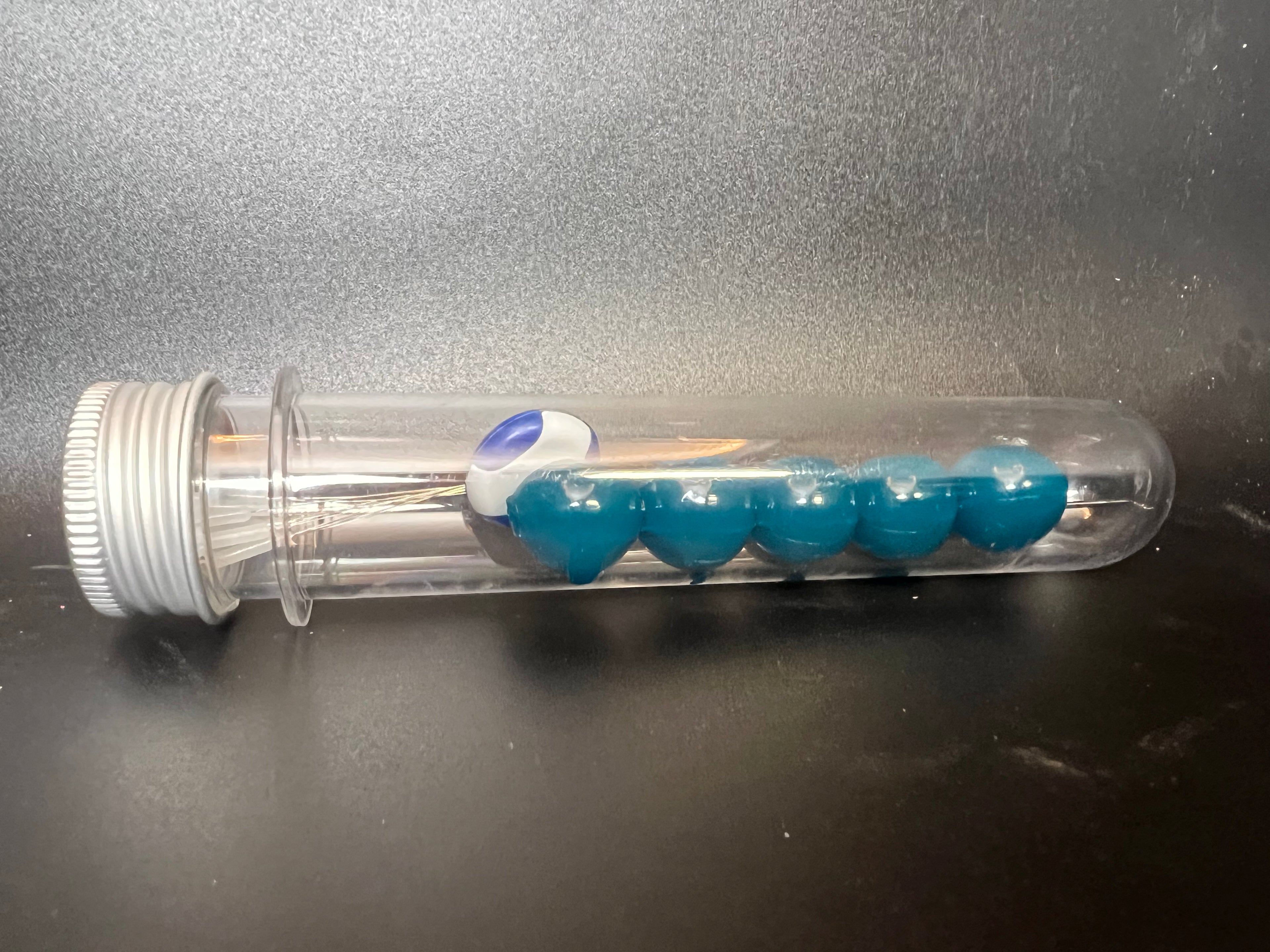 Soft plastic bead dispenser with teal beads for salmon & steelhead fishing