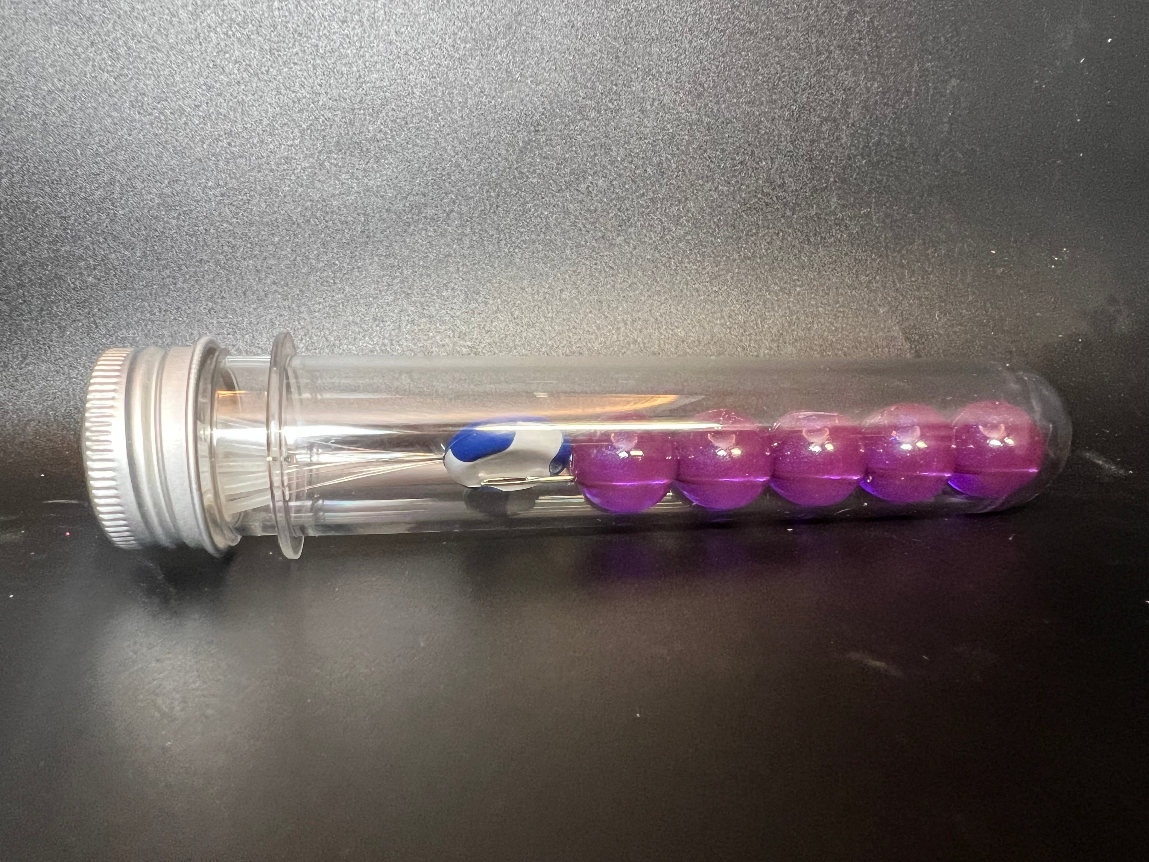 Roedeo soft plastic beads in clear dispenser tube; purple beads with blue accent