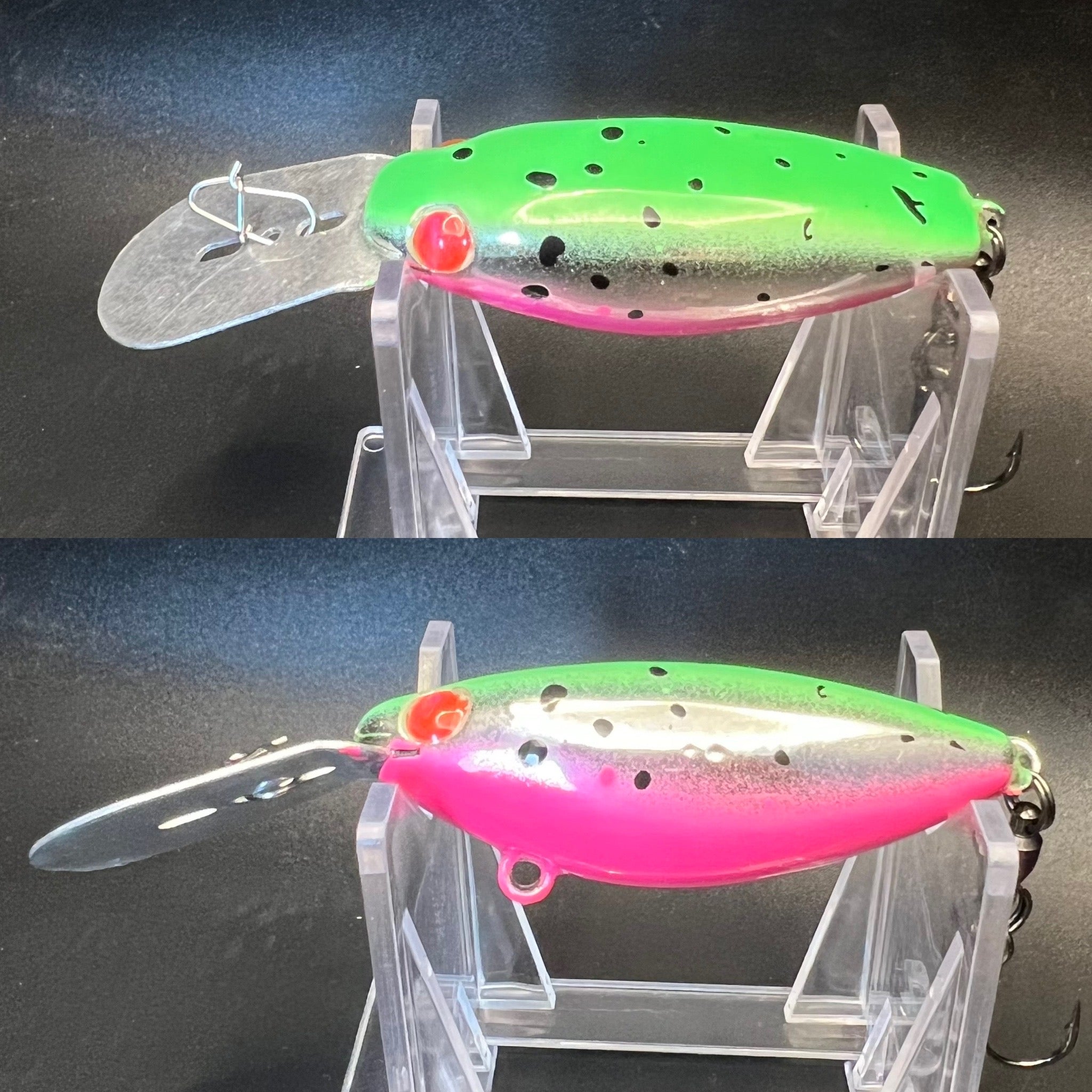 Green and pink trolling plug with wide lip and treble hook on clear stand