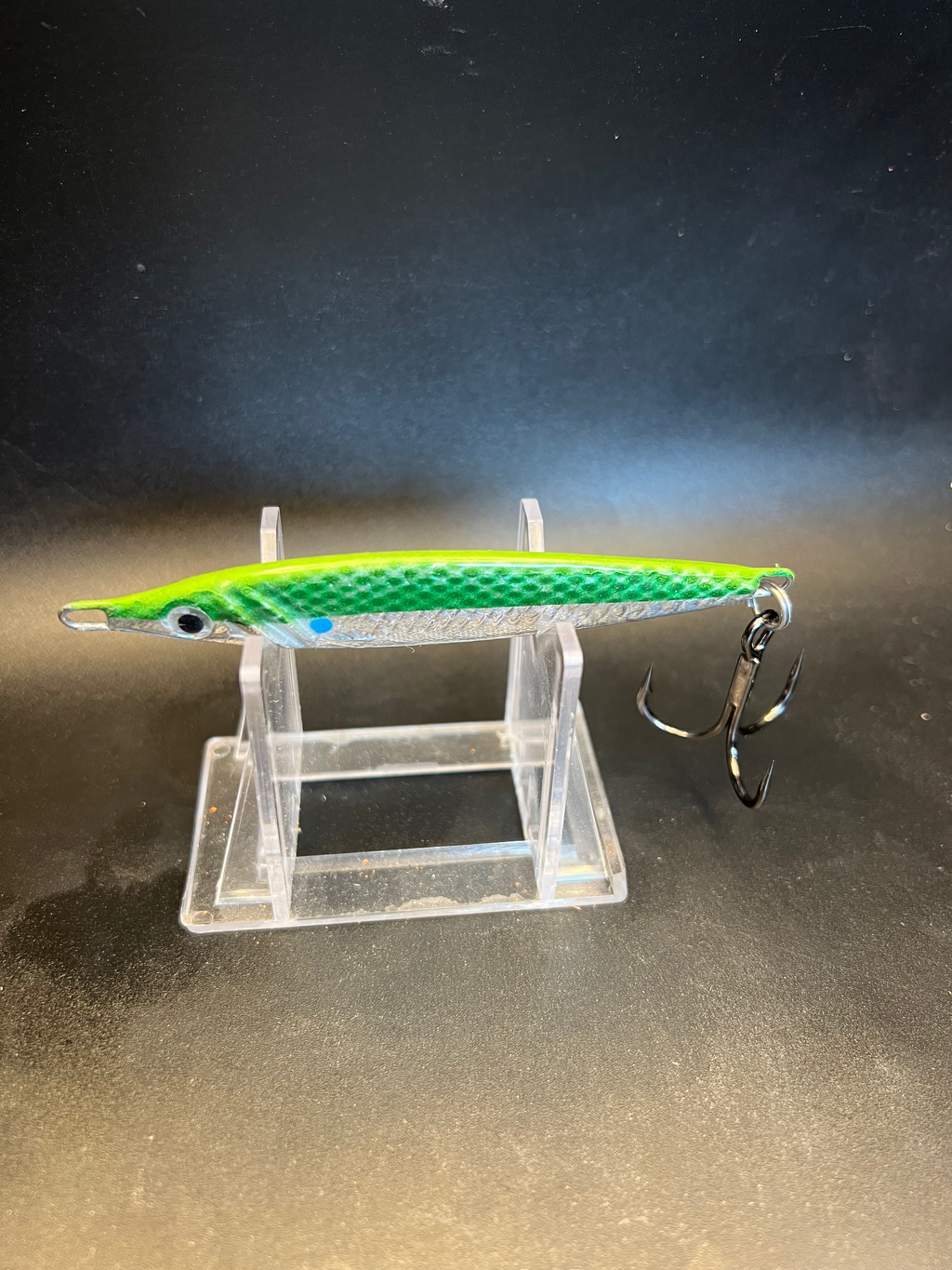 Jigging spoon in green with silver belly, black eye, split treble hooks