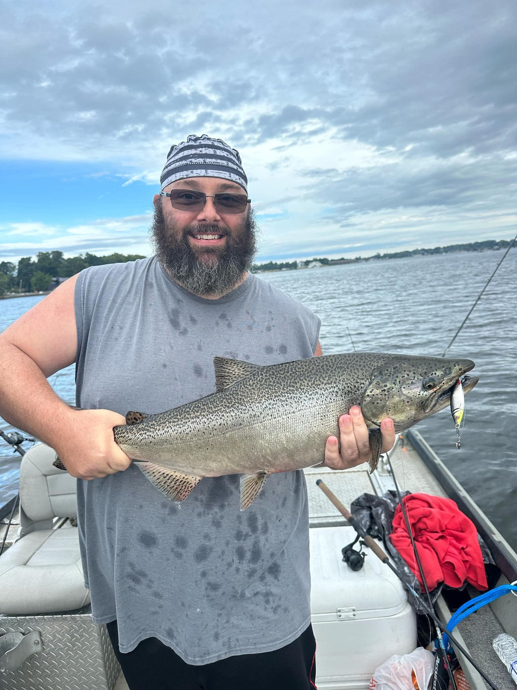 Jigging spoon visible in fish mouth: silver body with green-yellow eye