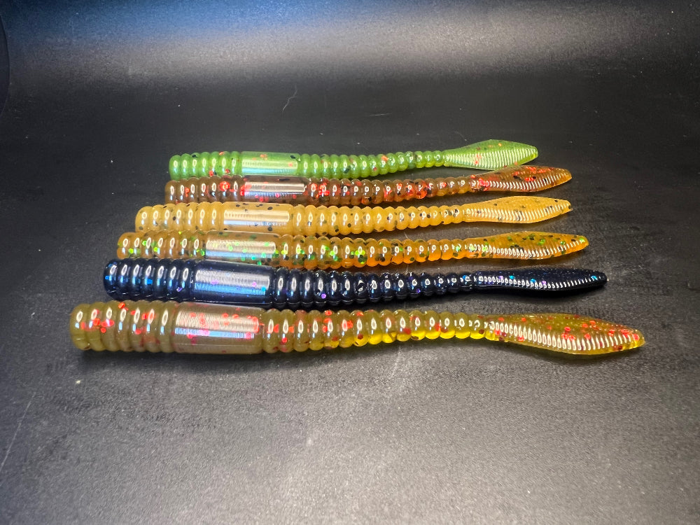 Assorted soft plastic crawler baits with segmented bodies and tail fins in mixed colors