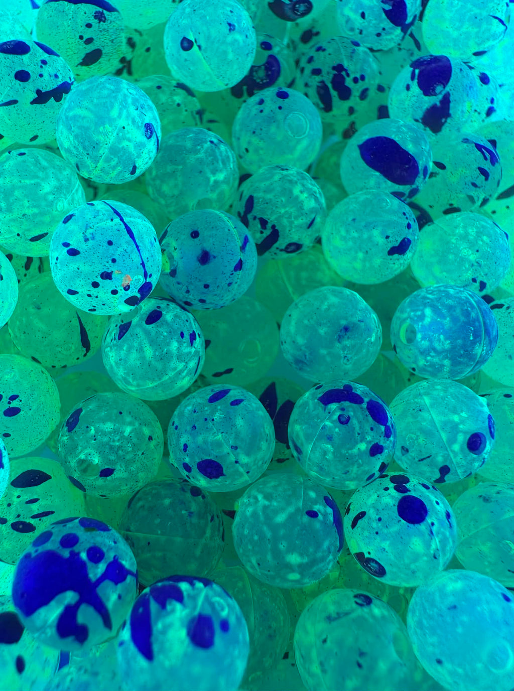 UV Glow fishing beads in green-blue with dark ink splatters