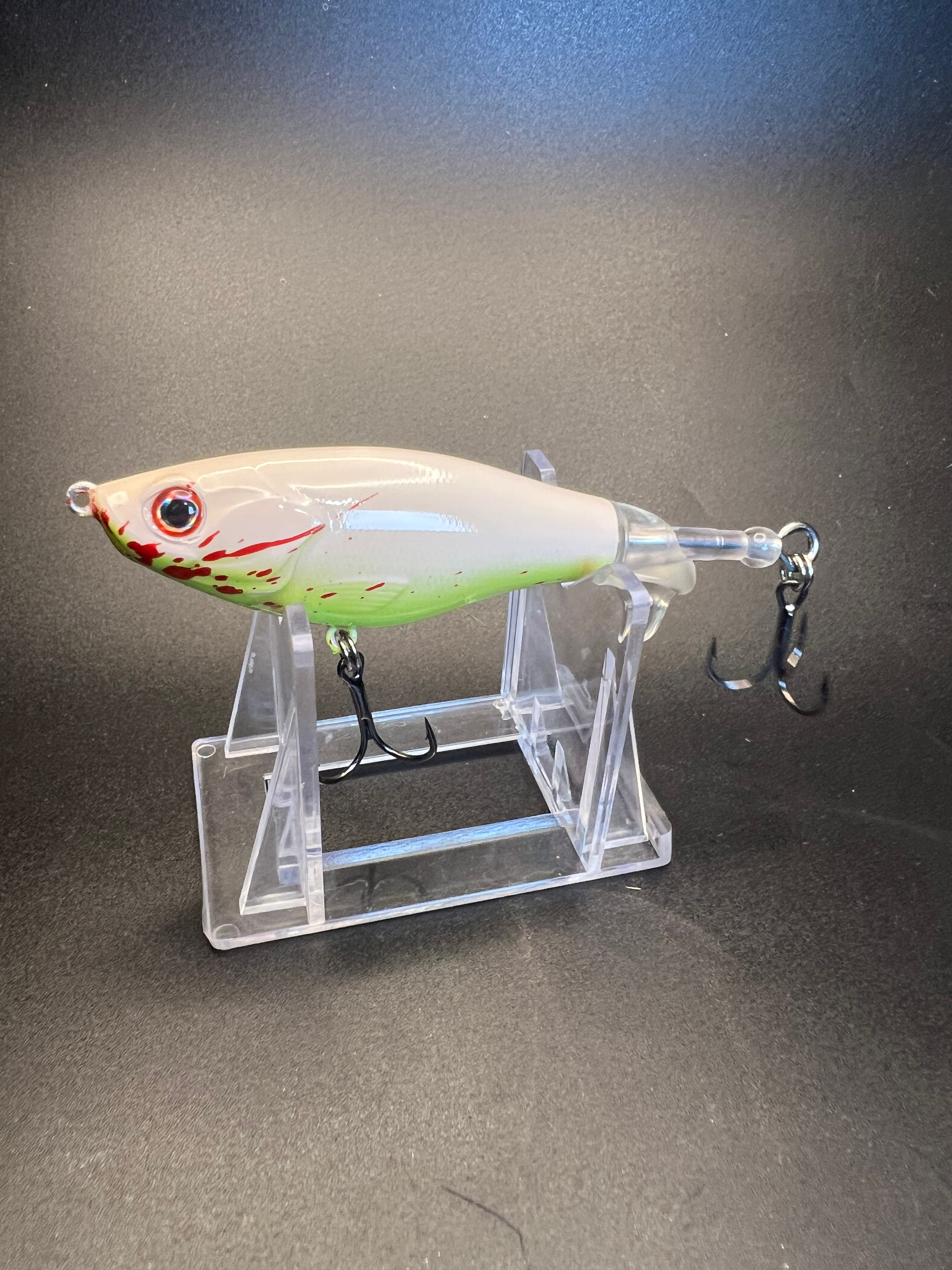White-green fishing lure with red spots, flat side, three strong hook setup